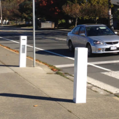 Passive activation bollard system for traffic warning system at crosswalk